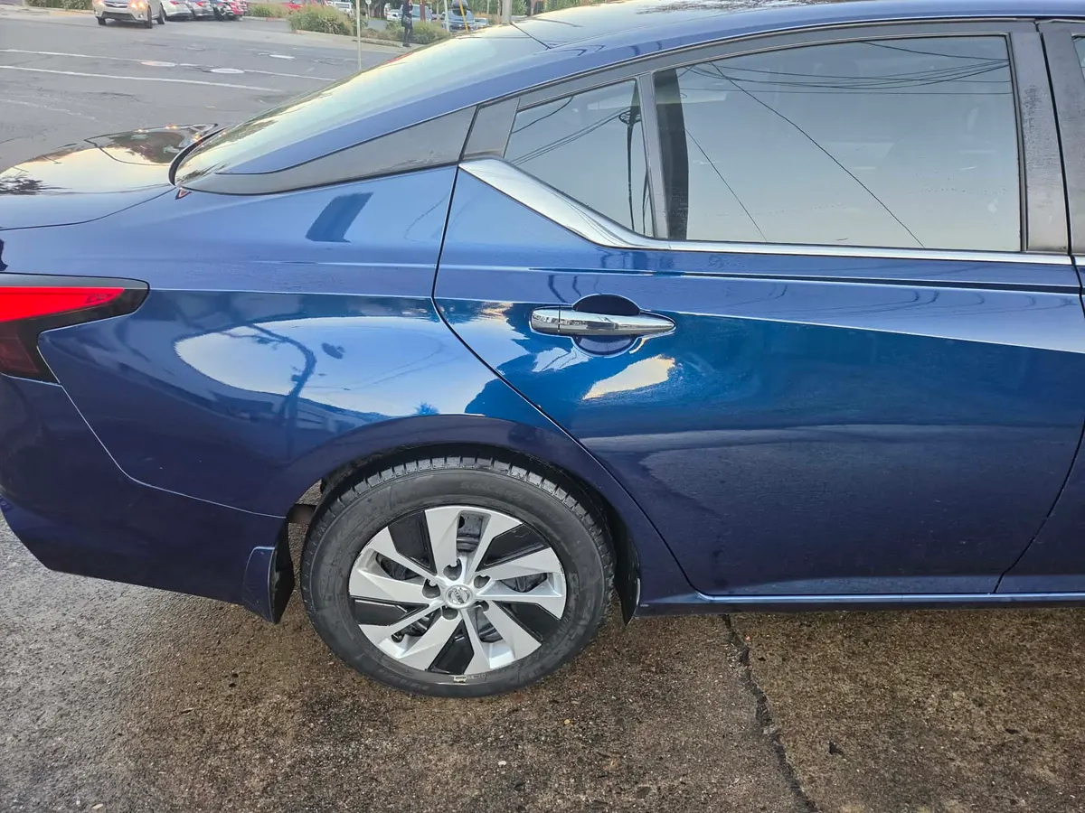 Side profile of a blue 2021 Nissan Altima after panel dent repair.